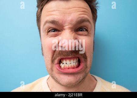 Kaukasischer Mann mit Schnurrbart, der wütend und wütend schrie. Stockfoto