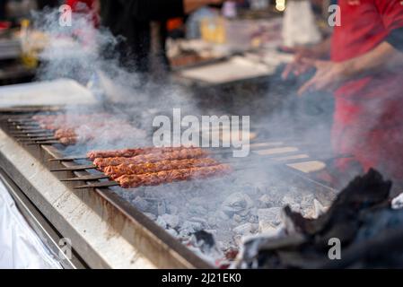 Traditioneller Adana-Kebab, gegrillt auf einem grill mit Rauch im Orangenblütenkarneval in der Stadt Adana in der Türkei. Editorial 03.25.2022 Stockfoto