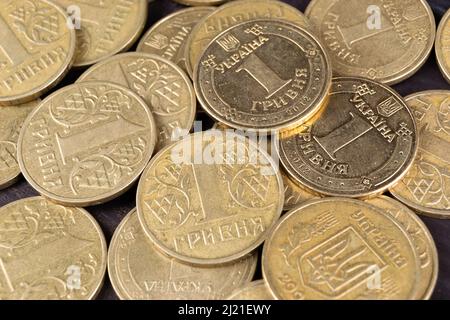 Ein Haufen ukrainischer Münzen mit einer Stückelung von einer Griwna verschiedener Jahrgänge. Draufsicht Stockfoto