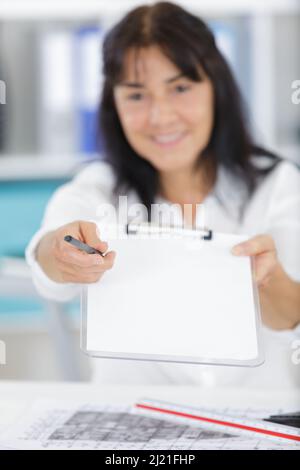 Eine Frau, die eine Zwischenablage zeigt Stockfoto