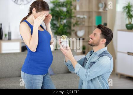 Mann, der Heiratsantrag an geliebte Schwangere macht Stockfoto