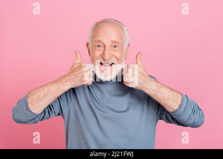 Foto von beeindruckt lustig Ruhestand Mann grau Pullover zeigt Daumen nach oben isoliert rosa Farbe Hintergrund Stockfoto