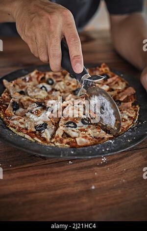 Closeup Hand Koch Bäcker schneiden Pizza in Küche Stockfoto