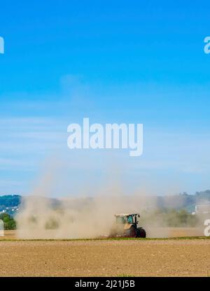 Bauer arbeitet in einer Dürreperiode mit seinem Traktor auf einem getrockneten Feld, Österreich, Eferding Stockfoto