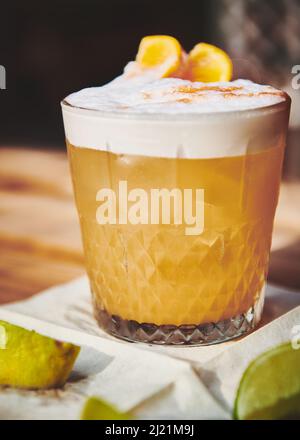 Ein schaumiges Bourbon-Sour-Cocktail, gekrönt mit angostura und Orangenscheiben Stockfoto