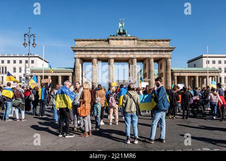 Deutschland, Berlin, Mitte, 27. März 2022. Appell für den Weltfrieden am Brandenburger Tor während der russischen Militärinvasion in die Ukraine. Menschen versammeln sich, um zu protestieren Stockfoto