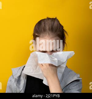 Krankes Mädchen, das ihre Nase in ein Taschentuch bläst, hat Symptome einer chronischen Sinusitis oder saisonalen Allergien Stockfoto