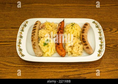 Auswahl an verschiedenen Würsten mit Sauerkraut und Kartoffelpüree Stockfoto