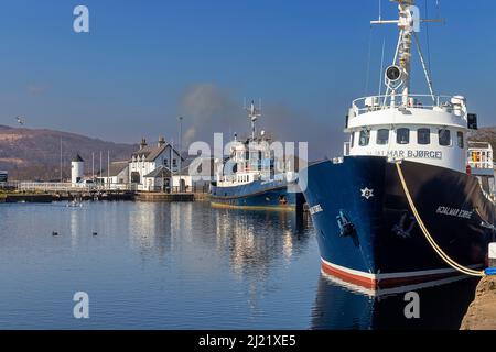 FORT WILLIAM SCOTLAND CORPACH ANLEGESTEG MIT FESTGESTEPPTEN BOOTEN UND WEISSEM LEUCHTTURM Stockfoto