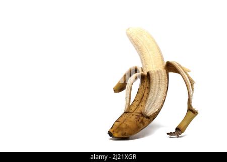 Nahaufnahme der halb geschälten sehr reifen gelben und braunen Banane bereit, zu essen mit Stücken gezogen und hängen auf weißem Hintergrund Konzept für en Stockfoto