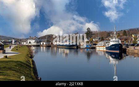 FORT WILLIAM SCOTLAND CORPACH ANLEGESTEG MIT SEESCHLOSS SCHOTTISCHE KANÄLE BAUEN WEISSEN LEUCHTTURM UND FESTGETÄUTE BOOTE Stockfoto