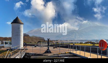 FORT WILLIAM SCOTLAND CORPACH PIER MIT WEISSEM LEUCHTTURM UND BEN NEVIS MIT SCHNEE Stockfoto