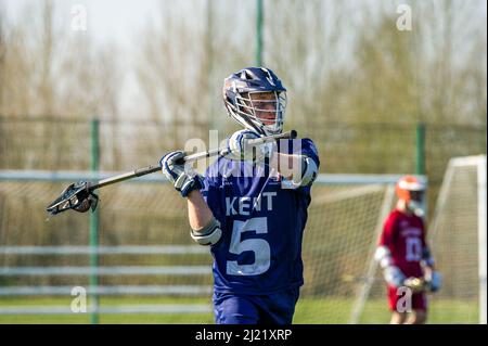 Ein Blick auf Kent Lacrosse Spieler hält Stick im Hintergrund des verschwommenen Fußballtor Stockfoto