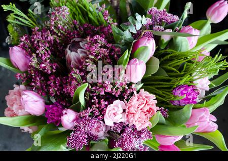 Ein Bouquet aus rosa Frühlingsblumen mit Tulpen, Heidekraut und Chrysanthemen. Stockfoto