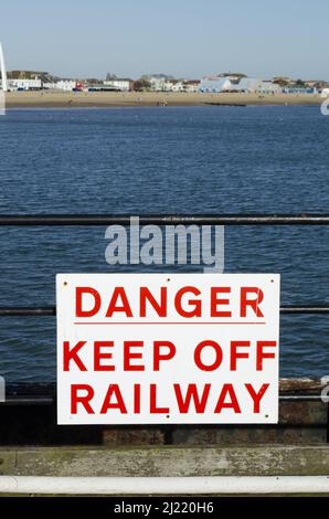 Ein Schild mit der Aufschrift „Danger Keep Off Railway“ am Pier von Southen. Stockfoto