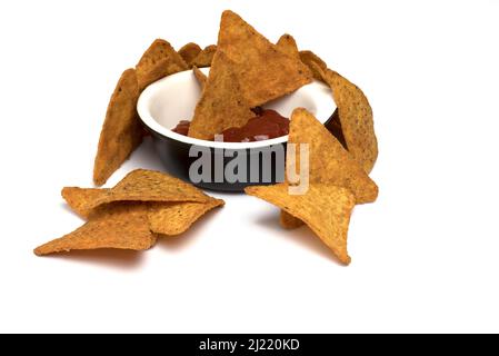 Nahaufnahme einer Keramikschale mit Salsa-Dipping-Sauce und dreieckigen Tortilla-Chips auf weißem Hintergrund für feurig-würzigen mexikanischen Snack zum Eintauchen Stockfoto