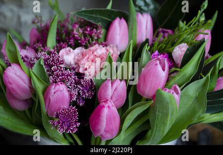 Ein Bouquet aus rosa Frühlingsblumen mit Tulpen, Heidekraut und Chrysanthemen. Stockfoto