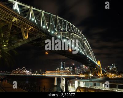 Die wunderschöne Hafenbrücke bei Nacht mit der Stadt im Hintergrund Stockfoto