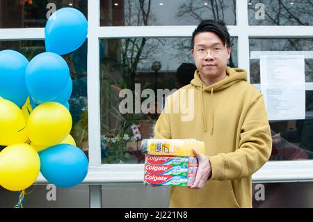 Jeffrey Lau (32 Jahre) aus Hongkong außerhalb des Prosperity Restaurants, Twickenham, Großbritannien. Seit Kriegsbeginn am 24.. Februar 2022 ist das Café zu einem Zentrum für Spenden für die Ukraine geworden. „Wir helfen gerne den Bedürftigen unter totalitärer Herrschaft. Wir haben einen ähnlichen Hintergrund - eine totalitäre Regierung. Wie vor zwei Jahren in Honk Kong - s fight for Freedom". Kredit: Tricia de Courcy Ling/Alamy Live Nachrichten Stockfoto