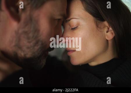 Nahaufnahme einer weinenden Frau, als sie ihren Mann umarmte. Stockfoto