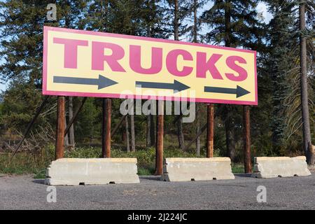 LKW-Plakatwand mit Richtungspfeilen auf einem LKW-Parkplatz. Stockfoto