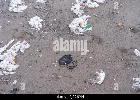 Strand voller Müll, nasser Tücher und Abfall, den die Leute in die Toilette werfen. Konzept der Meeresverschmutzung und Umweltzerstörung Stockfoto