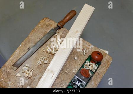 Hobel, Feile und Holzblock auf einem Hocker Stockfoto