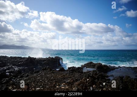 Ein malerischer Blick auf den felsigen Strand von Las Canteras mit Wellen, die auf den Klippen niederschmettern Stockfoto