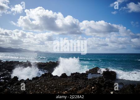 Ein malerischer Blick auf den felsigen Strand von Las Canteras mit Wellen, die auf den Klippen niederschmettern Stockfoto