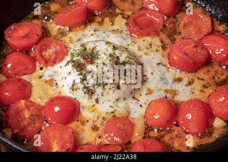 Koch kocht Speisen für die italienische Küche, Tomatensauce für Pasta, mediterranes Diätgericht, detaillierte Ansicht der Hände und Pfanne mit gebratenen Tomaten. Stockfoto