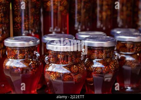 Pinienzapfen in Honig. Gläser mit Konfitüre aus Kiefernholz. Stockfoto