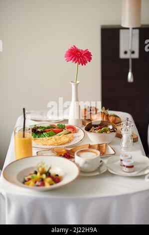Vertikale Fotografie von servierten, frischen Backwaren, Croissants, Obstsalat, Kaffee. Stockfoto