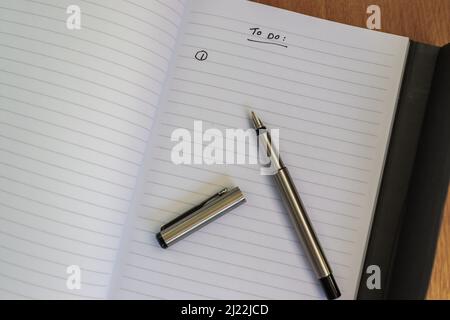 Schreiben mit einem Füllfederhalter, in einem Notizblock / Tagebuch Stockfoto