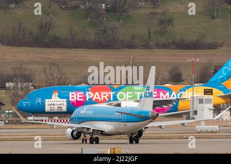 Zürich, Schweiz, 24. Februar 2022 KLM Royal Dutch Airlines Embraer ERJ-172 vor einem Emirates Airbus A380-861 mit einem speziellen EXPO p Stockfoto