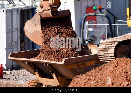 Taffs Well, Wales - März 2022: Mechanischer Bagger kippt großen Kies in einen Muldenkipper Stockfoto