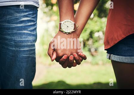 Ich kann alles mit deiner Hand in meiner tun. Zugeschnittene Aufnahme eines nicht erkennbaren Paares, das mit der Hand draußen steht. Stockfoto