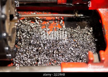 Viele Metallspanungen aus der Nähe, nach der Arbeit an einer Fräsmaschine oder CNC-Maschine. Makro Textur Metallteile. Stockfoto