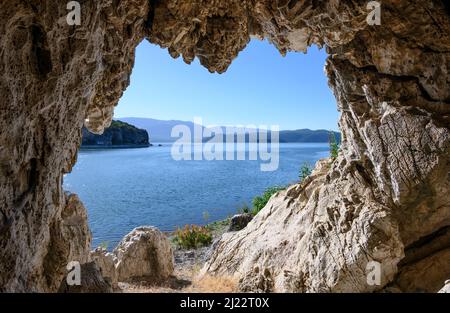 Blick über den Prespa-See in Richtung Albanien von einer Höhle am Ufer in der Nähe des Dorfes Psarades in Mazedonien, Nordgriechenland. Stockfoto