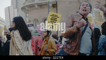 London, Großbritannien - 03 19 2022: Protestler mit Schild am Portland Place, ‘Black Liberation: Stop Wars! Stop Racism!’, jährlich ‘March Against Racism’. Stockfoto