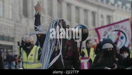 London, Großbritannien - 03 19 2022: Schwarze Frau protestiert in der Regent Street, unter einer Menschenmenge, ‘Marsch gegen Rassismus’, ‘UN Anti-Rassismus-Tag’. Stockfoto