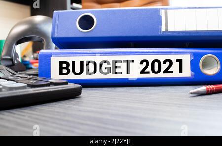 BUDGET 2021 Text Inschrift auf Ordner mit Rechner und Stift auf weißem glänzenden Tisch. Stockfoto