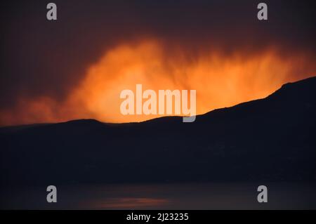 Intensiver roter und oranger Sonnenuntergang wie brennender Himmel im Winter.Sonnenuntergang nach den Bergen, wie Feuerflammen Stockfoto