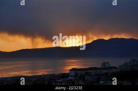 Intensiver roter und oranger Sonnenuntergang wie brennender Himmel im Winter.Sonnenuntergang nach den Bergen, wie Feuerflammen Stockfoto