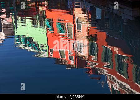 Italien, Venedig, farbenfrohe Häuser auf der venezianischen Insel Burano, die sich zu einem Kanal spiegeln Stockfoto