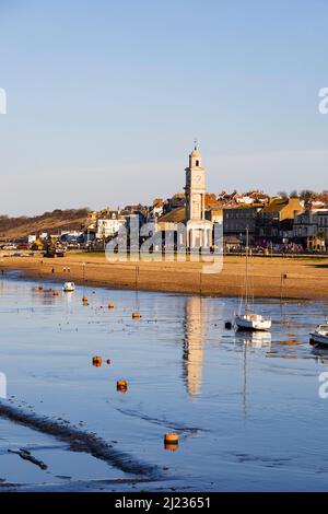 Strandpromenade mit Flut. Der Uhrenturm spiegelt sich im Meerwasser wider.Herne Bay, Kent, England Stockfoto