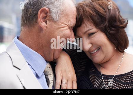 Ein Lachen teilen. Nahaufnahme eines reifen Paares, das einen intimen, glücklichen Moment miteinander teilt. Stockfoto