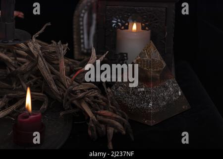 Tarot-Karte, die auf einem Naturschaugerät verteilt ist. Handgefertigte Tarot-Karten auf einem dunklen Holztisch, umgeben von getrockneten Kräutern, blauen Blumen und weißen Kerzen. Blau Stockfoto