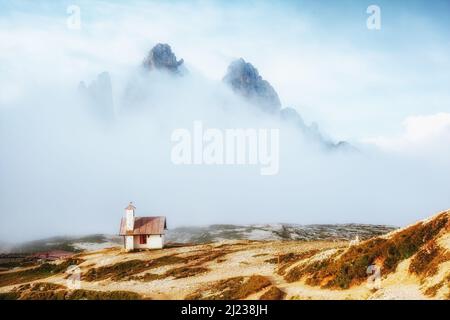 Nebel Blick auf den Nationalpark Tre Cime di Lavaredo mit Rifugio Locatelli. Dramatische und wunderschöne Szene. Ort berühmten Resort Auronzo, Dolomi Stockfoto