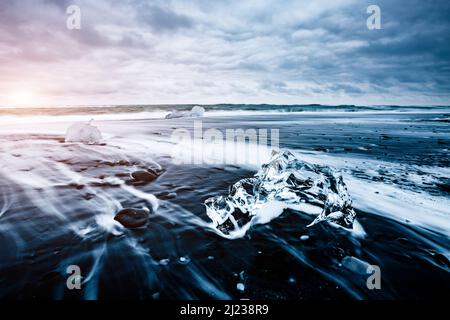 Große Stücke des Eisbergs, die Funkeln auf dem schwarzen Sand. Malerische und schöne Szene. Lage berühmte Ort Jokulsarlon Lagune, Vatnajökull nati Stockfoto