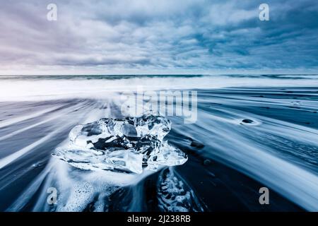 Große Stücke des Eisbergs, die Funkeln auf dem schwarzen Sand. Malerische und schöne Szene. Lage berühmte Ort Jokulsarlon Lagune, Vatnajökull nati Stockfoto